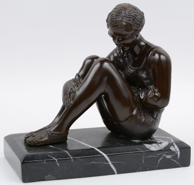 “Zittende vrouw”. Een beeld van bruingepatineerd brons op marmeren sokkel. Naar een werk van A. Moreau.