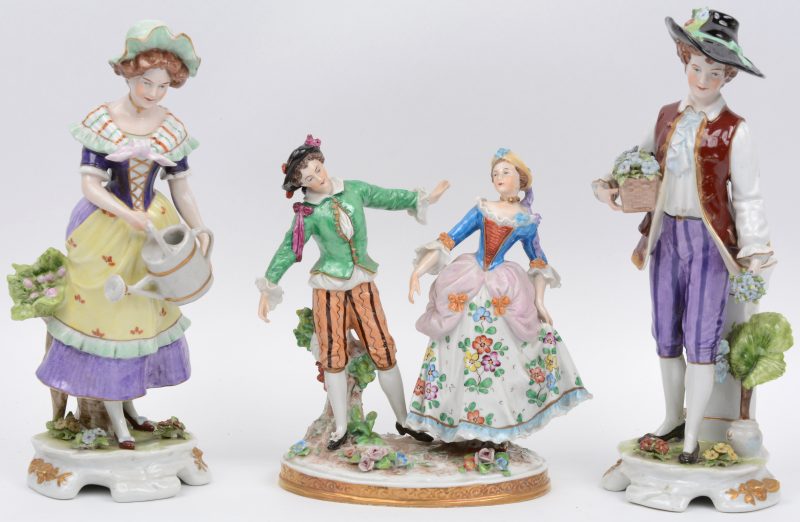 Een jongen met bloemen, een dame met gieter en een groep van een dansend koppel van meerkleurig porselein. Onderaan gemerkt.