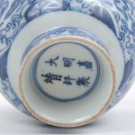 Een kom van Chinees porsleein met en blauw en wit decor van vogels en paarden. Onderaan gemerkt.