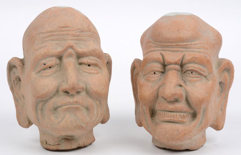 Een par karakterhoofden van deels geglazuurd terracotta.