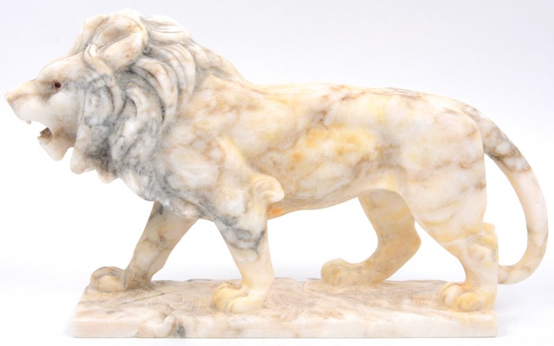 Een leeuw van gebeeldhouwd marmer met glazen oogjes.