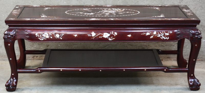 Een Chinese salontafel van roodgelakt hout en versierd met inlegwerk van parelmoer.