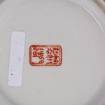 Een schaal van Chinees porselein met een famille rosedecor van personages. Onderaan gemerkt.