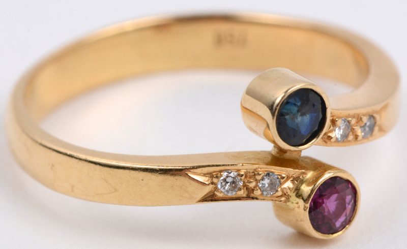“Toi en Moi”. Een 18 karaats geel gouden ring bezet met een robijn en een saffier met een gezamenlijk gewicht van ± 0,20 ct. en kleine briljantjes.