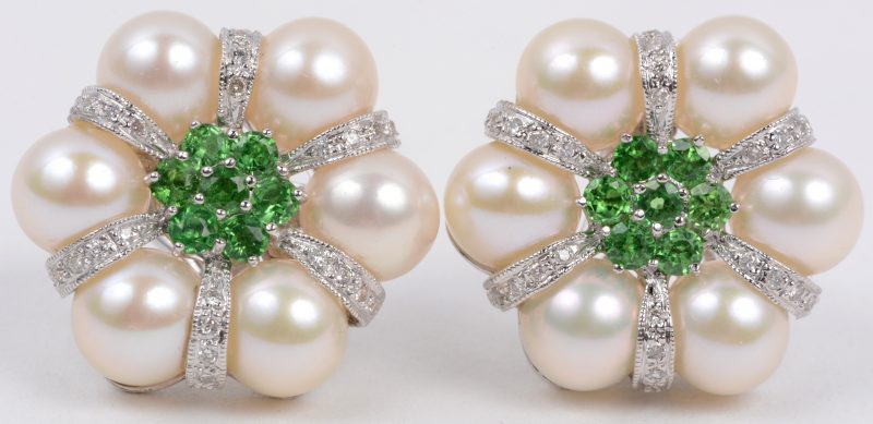 Een paar 18 karaats wit gouden oorbellen bezet met diamanten met een gezamenlijk gewicht van ± 0,30 ct. tzavorite en parels.
