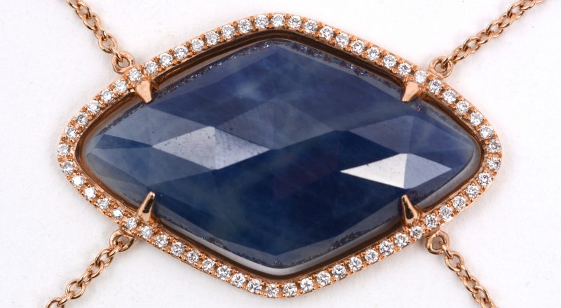 Een 18 karaats rooskleurige armband bezet met diamanten met een gezamenlijk gewicht van ± 0,30 ct. en een saffier van ± 17 ct.
