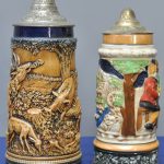 Een lot van drie Duitse bierpullen van meerkleurig aardewerk met metalen kleppen.
