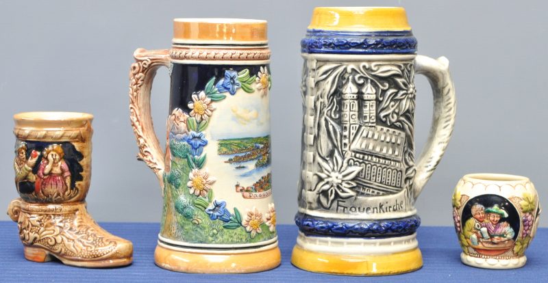 Een lot van twee Duitse bierpullen van meerkleurig aardewerk, een laarsvormige kleine pul en een wijnbeker.