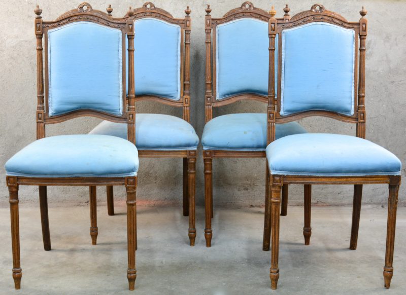 Een serie van vier stoelen van gesculpteerd notenhout in Lodewijk XVI-stijl. Lichtblauwe bekleding. Omstreeks 1900.