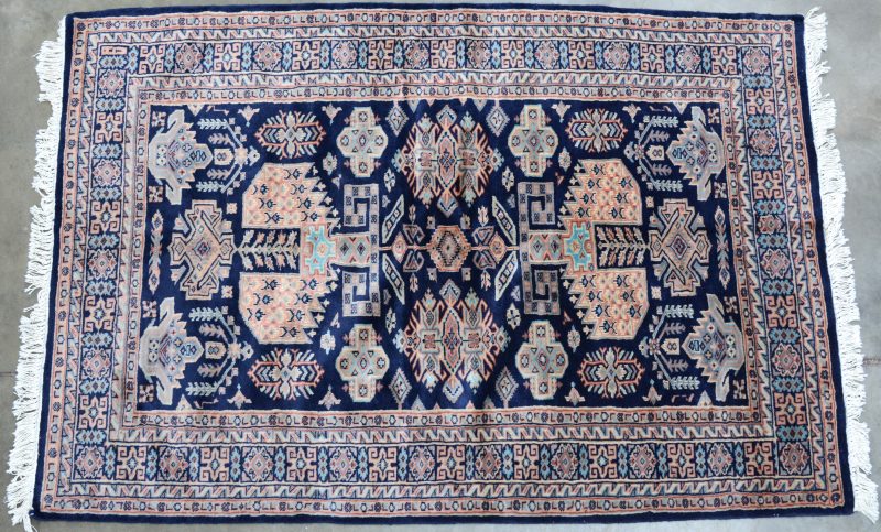 Een handgeknoopt Pakistaans karpet van wol.
