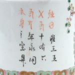 Een theepot van meerkleurig Chinees porselein met cahepots met bloeiende planten in het decor.