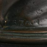 “De knuffelaarster”. Een beeld van donkergepatineerd brons op marmeren sokkel naar een werk van Bruno Zach.