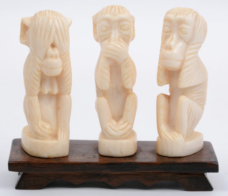 “Horen, zien en zwijgen”. Een groepje van gesculpteerd Afrikaans ivoor op een houten sokkeltje.