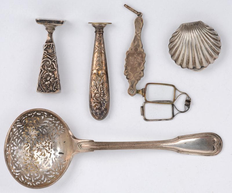 Een lot zilveren voorwerpen, bestaande uit twee verschillende wasstempels, een strooilepel en een schelpvormig pillendoosje.We voegen er een 10 Karaats gouden lorgnet aan toe.