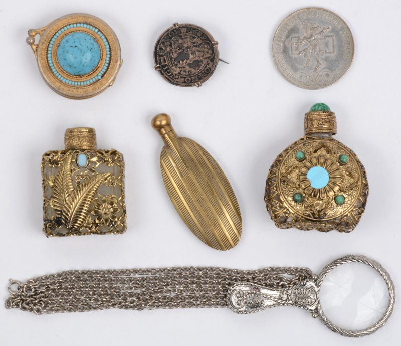 Een lotje varia, bestaande uit drie verschillende parfumflesjes, een loepje, een pillendoosje en twee munten.