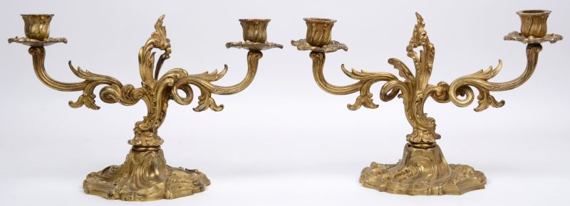 Een paar kandelaars van verguld brons in Lodewijk XV-stijl met twee lichtpunten.