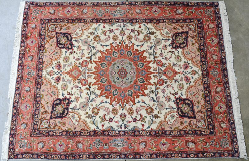 Een handgeknoopt Perzisch karpet van wol en zijde.