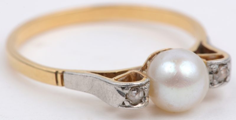 Een 18 karaats geel gouden ring bezet met twee diamantjes oude slijp en een parel.