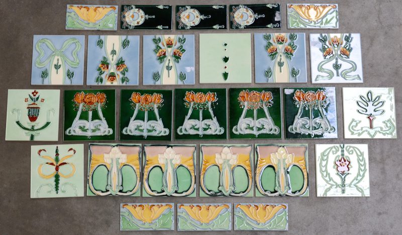 Een lot van 19 grote en 8 kleine tegels met diverse decors in art nouveau en decostijl.