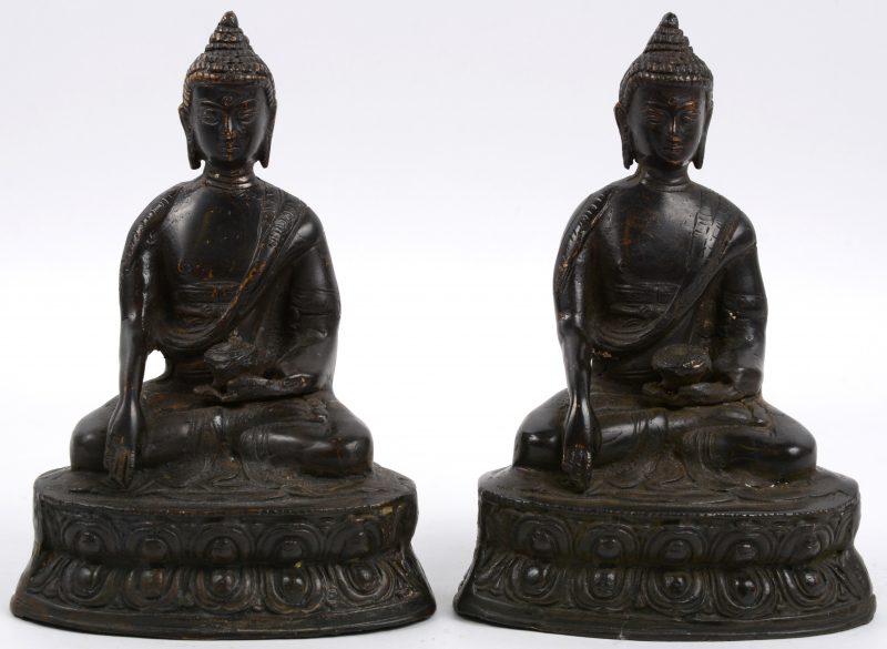 Een paar zittende Boeddha’s van donkergepatineerd brons.