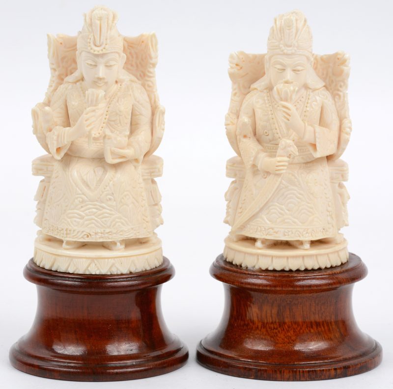 “Keizer en Keizerin”. Twee beeldjes van gesculpteerd ivoor op houten voetstukjes.