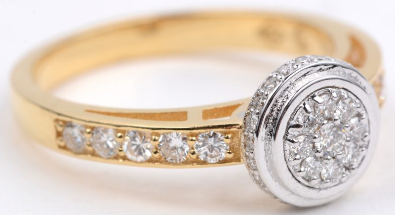 Een 18 karaats wit en geel gouden ring bezet met diamanten met een gezamenlijk gewicht van ± 0,46 ct.