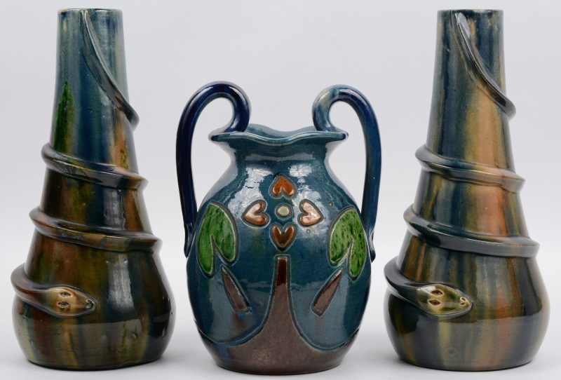 Een lot Belgisch aardewerk, bestaande uit een paar siervazen en een sierkruik met een decor van gebladerte.