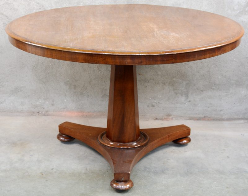 Een ronde tafel van gefineerd hout in Biedermeierstijl met kantelend blad.