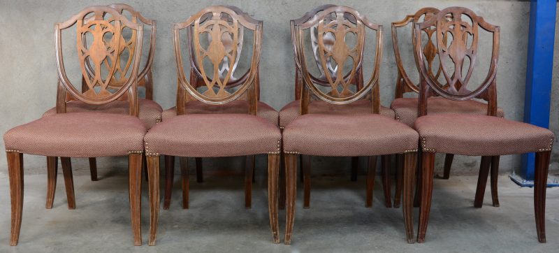 Een reeks van acht mahoniehouten stoelen met stoffen bekleding.