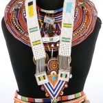 Juwelen waaronder halssnoeren, armbanden, hoofdversieringen, centuren en een knots. Aangekocht ter plaatse.