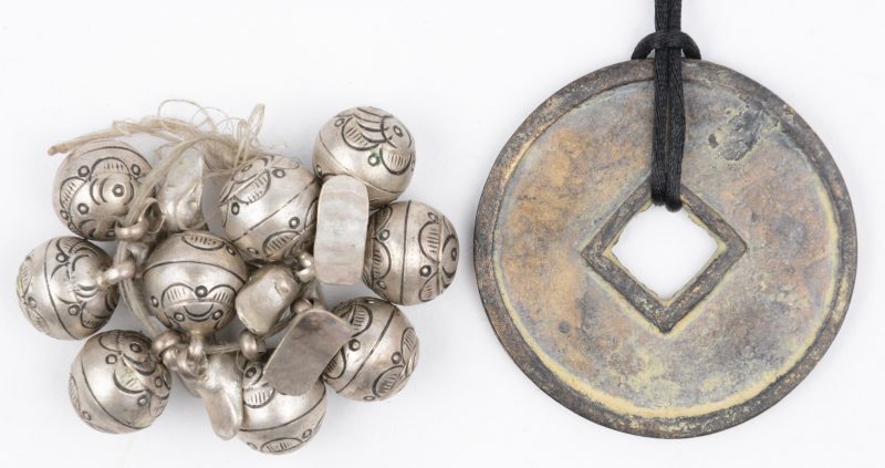 Negen verzilverd metalen knopen voor de traditionele klederdracht en een afgietsel van een munt.