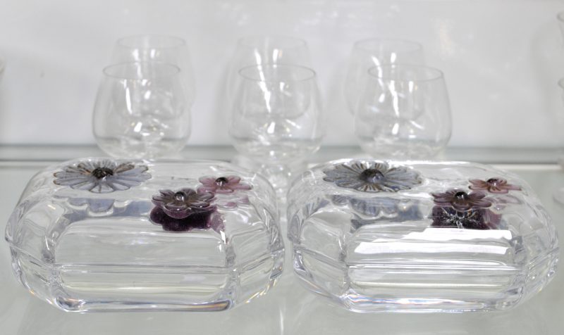 Een lot kristal, bestaande uit zes aperitiefglaasjes en twee dekseldoosjes met bloemen in reliëf op het deksel. Allen gesigneerd onderaan.