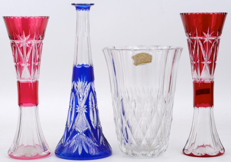 Een lot kristal, bestaande uit een blauwe karaf, twee mauve fluitvazen en een kleurloze vaas. De laatste gemerkt van Val St. Lambert.