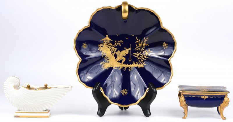 Een lotje porselein, bestaande uit een vide-poche en een juwelendoosje van blauw en verguld en een inktpotje van wit en verguld porselein met een bloemendecor. Resp. Baudour, Limoges en Italië.