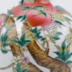 Een Qinglong vaas met een polychroom decor van perziken