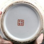 Een Qinglong vaas met een polychroom decor van kraanvogels en witte bloesems op een lichtgele ondergrond.