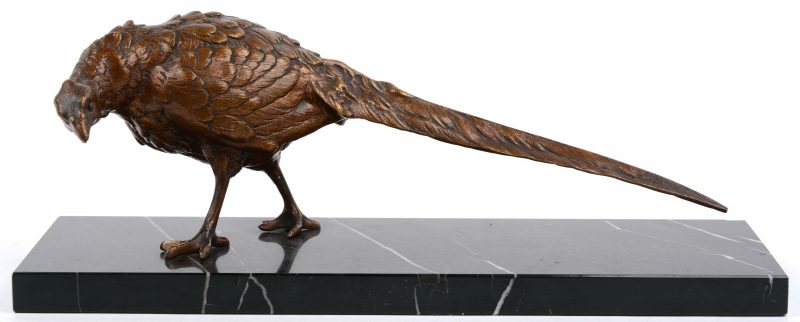 Een fazant van bruingepatineerd brons op een zwart marmeren voetstuk.