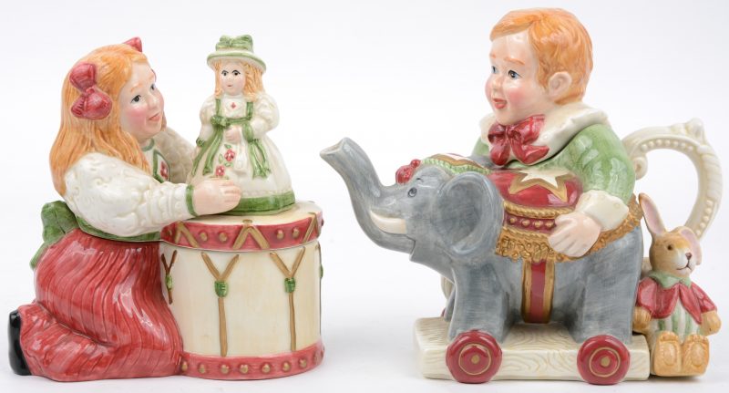 Een theepotje en een dekseldoosje van meerkleurig porselein in de vorm van een jongen met een olifant en een koniijn en een meisje met een pop op een trommel. Onderaan gemekt. Recent werk.