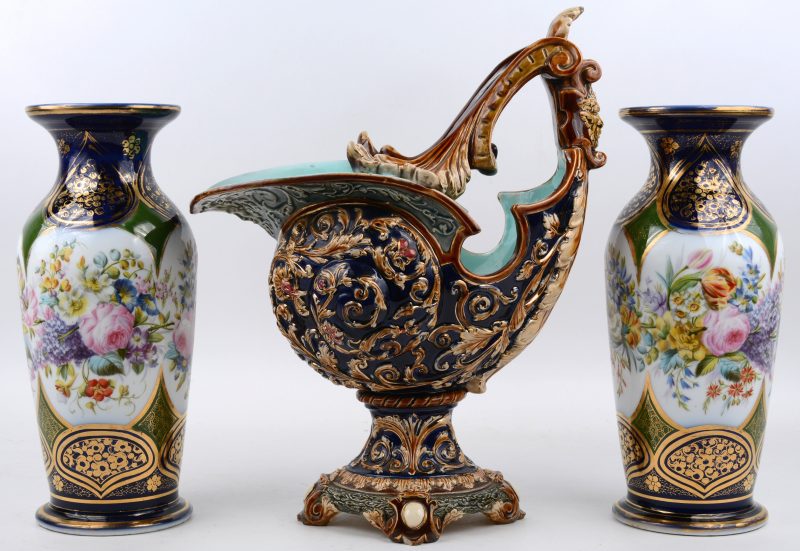 Twee vazen en een schelpvormige siercoupe van kobaltblauw en verguld aardewerk, waarbij de eerste twee met een Handgeschilderd bloemendecor. De tweede onderaan gemerkt “W.S. & S.”.