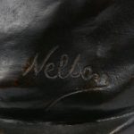 Een meisjesbuste van donkergepatineerd brons, gesigneerd ‘Nelson’.