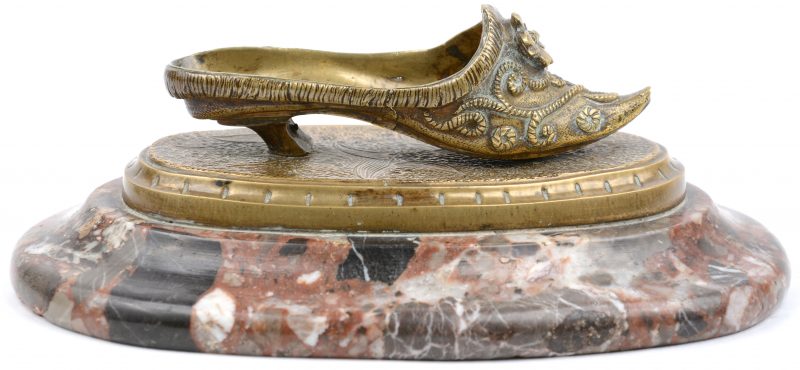 Een bronzen muiltje op een marmeren voetstuk. Einde XIXe eeuw.