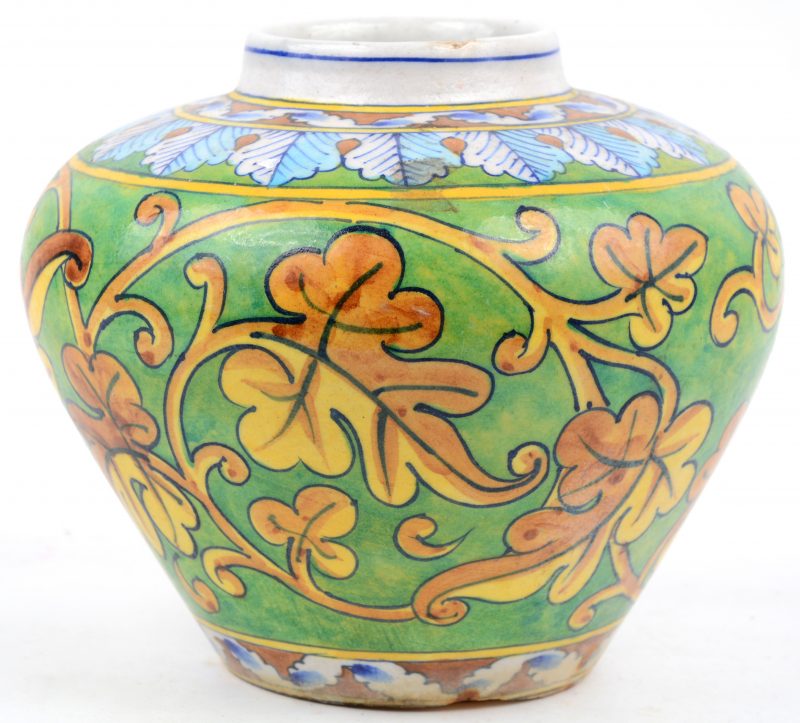 Een aardewerken vaas met een handgeschilderd decor van gebladerte. Indo-Perzisch.