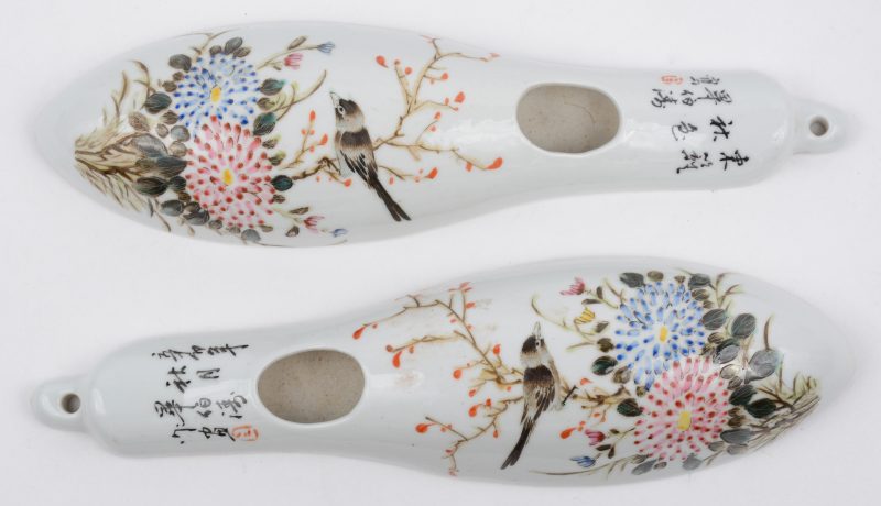 Een paar wandbakjes van Chinees porselein met een meerkleurig decor van een vogeltje met bloemen.