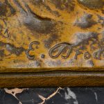 “Zittende boer”. Een beeld van bruingepatineerd brons op een zwart marmeren voetstuk. Gesigneerd.