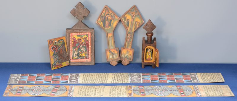 Drie gebeeldhouwde houten devotiekruisen met iconen. Ethiopië. We voegen er twee perkamenten geïllustreerde tekstbladen bij.