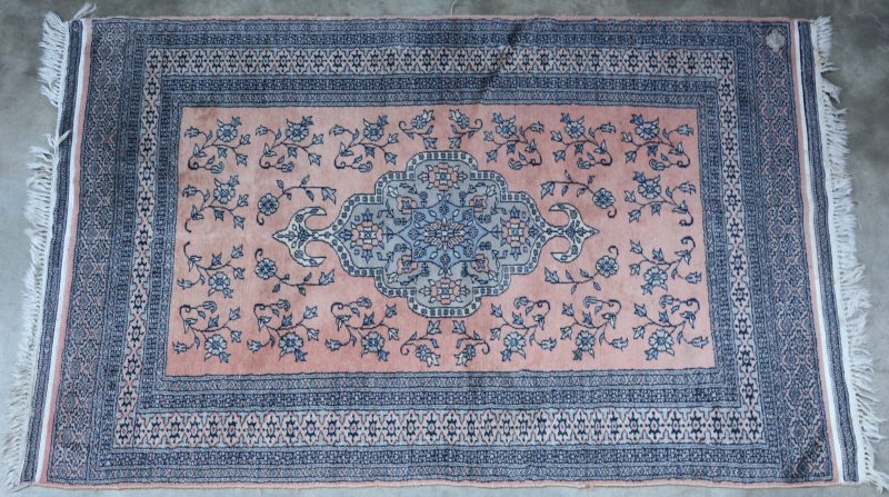 Een handgeknoopt Perzisch tapijt van wol en katoen met een centraal medaillon en bloemen in het decor. Gesigneerd.