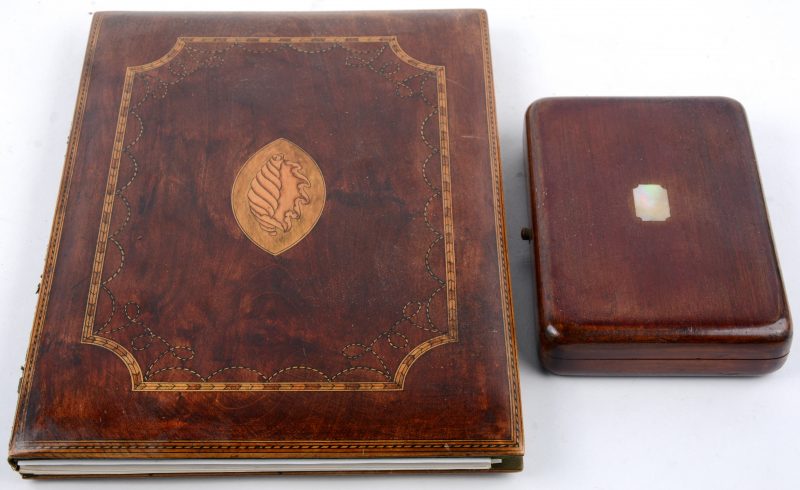Een houten doosje, sober versierd met parelmoer en een notietiekaft van gefineerd hout, versierd met inlegwerk.
