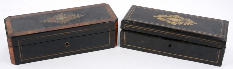 Twee verschillende handschoenkastjes van gefineerd en zwartgelakt hout, het deksel telkens versierd met messingen inlegwerk.