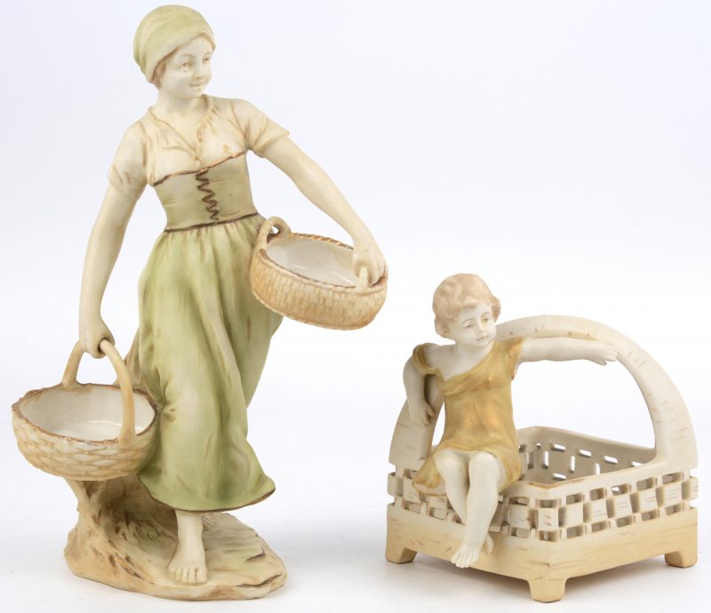 Een mandje met een zittend kindje en een jonge vrouw met twee manden van meerkleurig porselein. Onderaan gemerkt. Begin XXe eeuw.