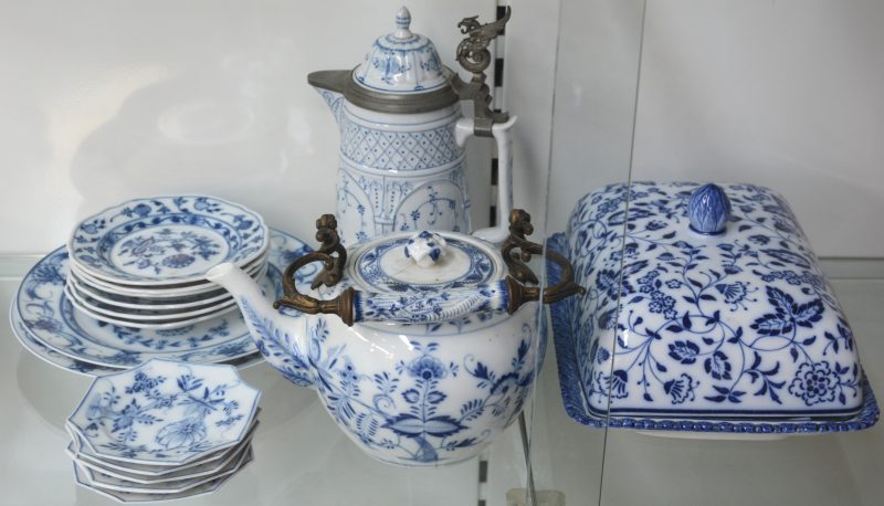 Een lot blauw en wit porselein, bestaande uit een aspergeschaal, een theepot, een koffiepot, versierd met een tinnen griffioen, vijf achthoekige bordjes, zes dessertbordjes en twee grote borden. Grotendeels gemerkt van Meissen.